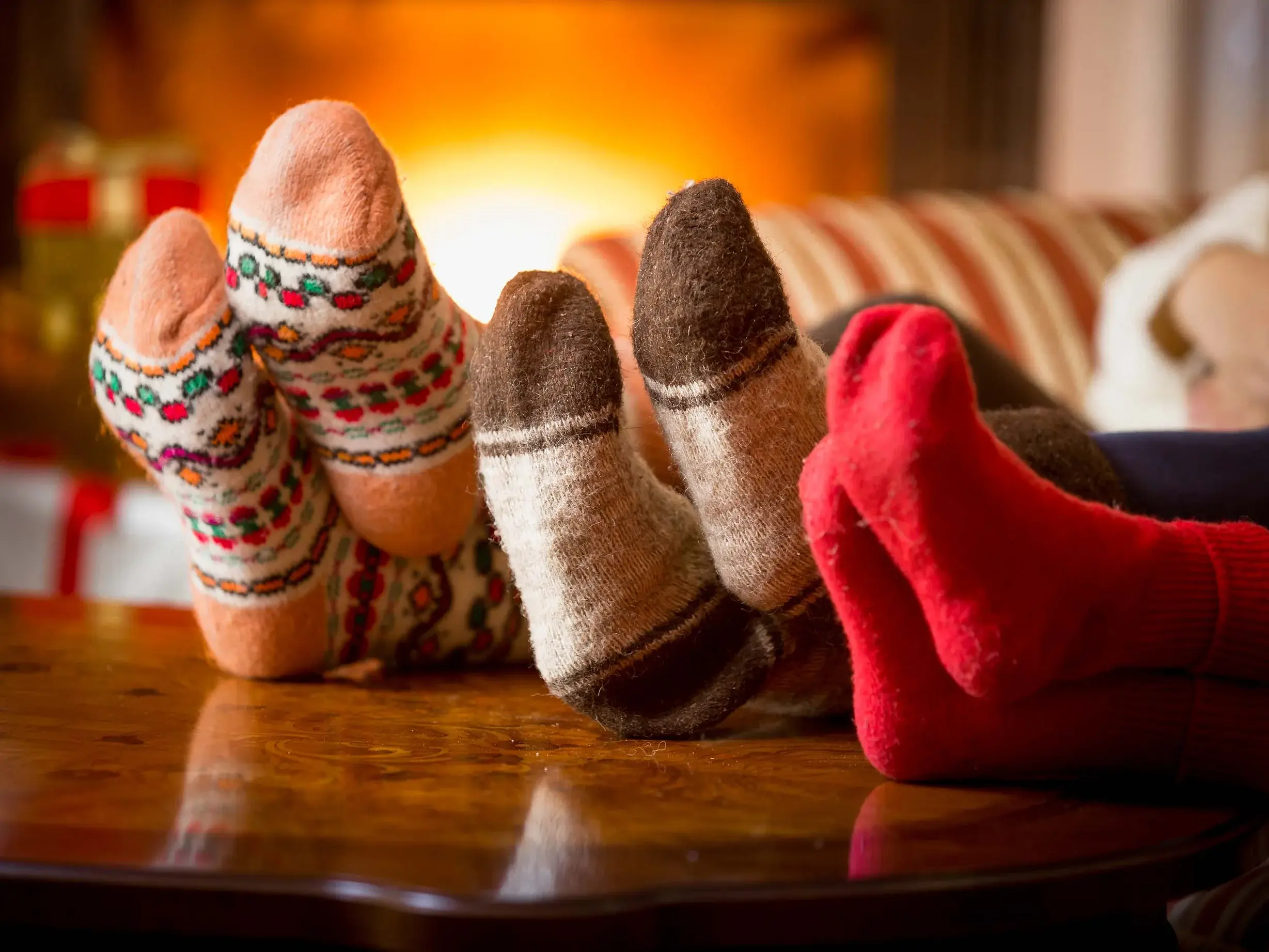 Drei Personen mit den Füßen auf dem Tisch und bunten Socken an