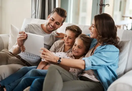 Familie sitzt auf dem Sofa Espelkamp Energieservice Westfalen Weser